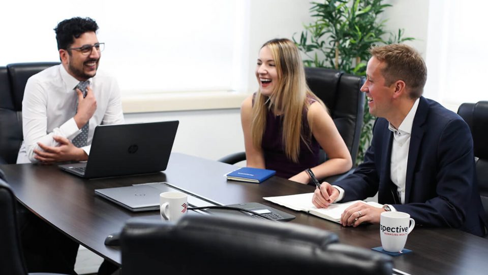 Three people having a laugh at a meeting