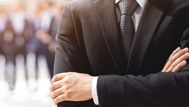 Someone in a suit with their arms crossed