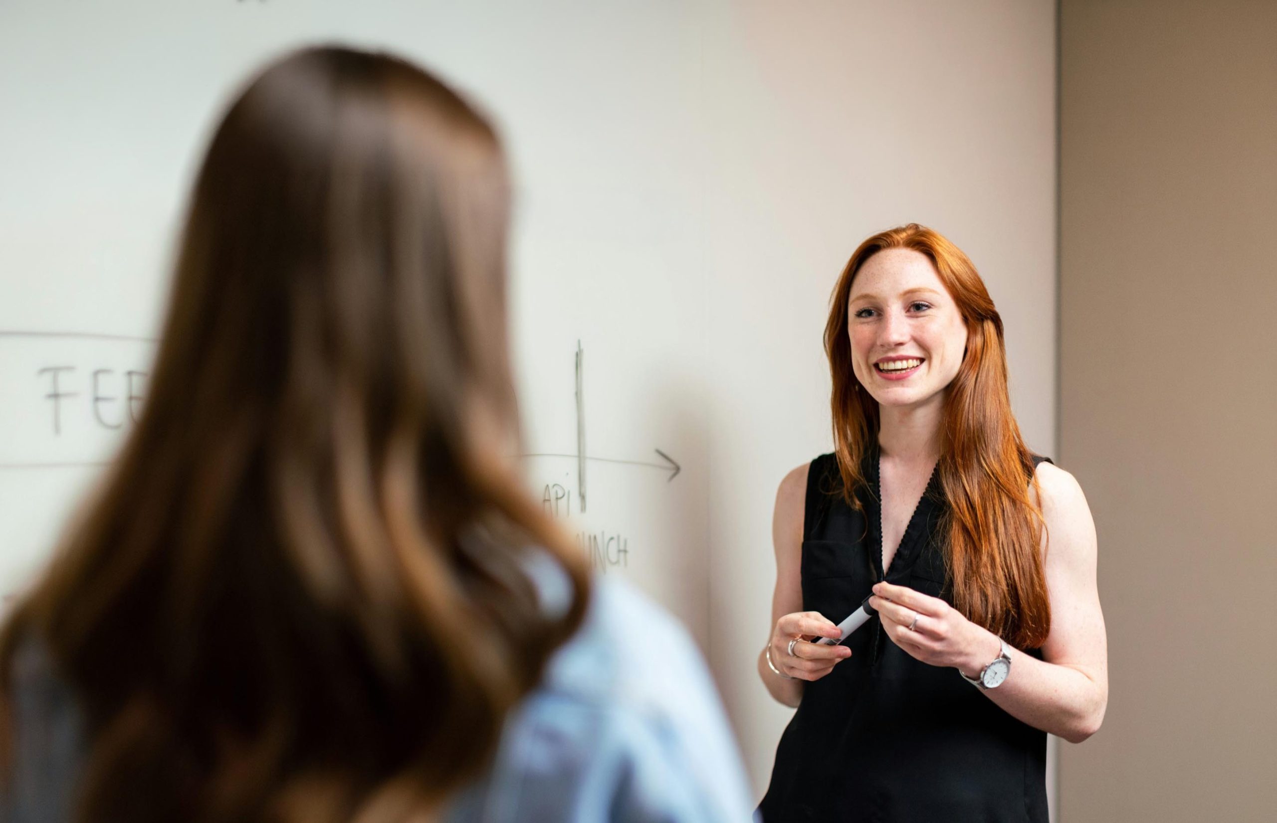 person teaching in front of white board